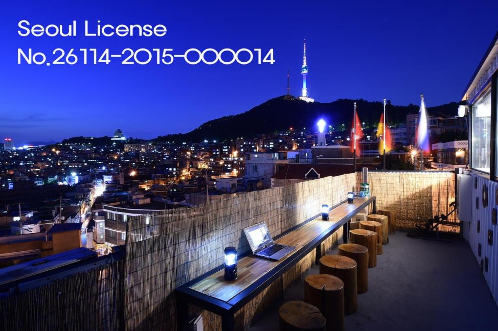 a laptop sitting on a ledge on a rooftop at night at Photo Park Guesthouse in Seoul