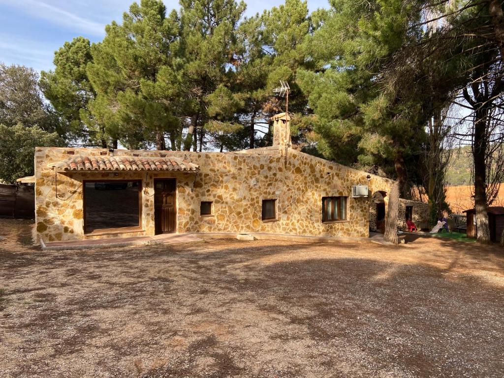 a stone building with a garage in a yard at Casa rural La Marquesa - Cuenca in Valera de Abajo