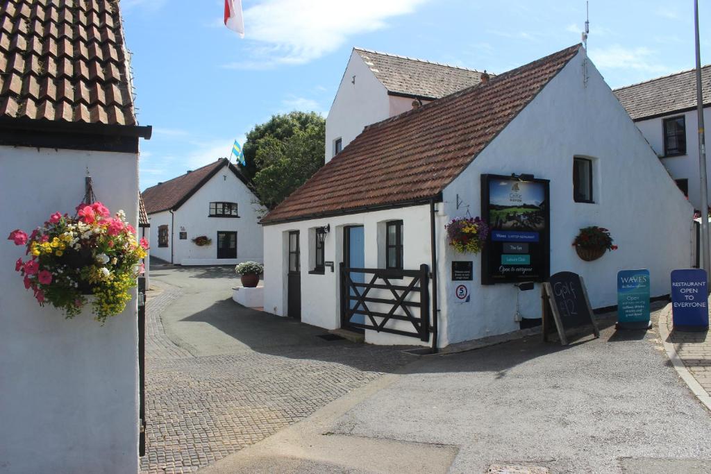 a white building with a gate in a street at Celtic Haven in Tenby