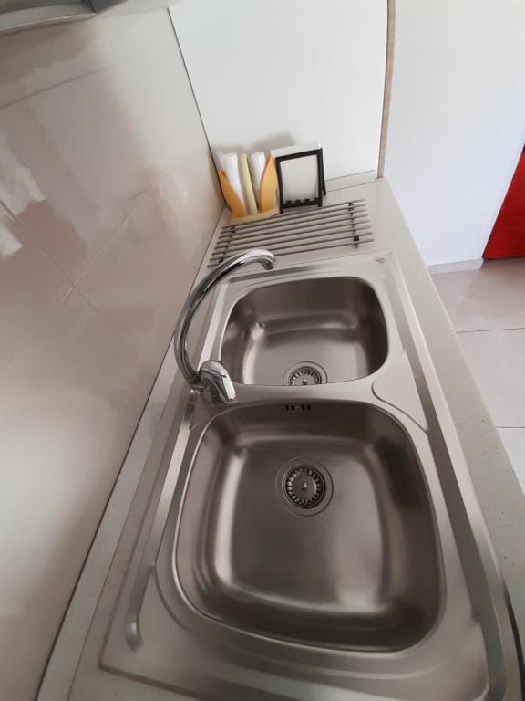 a stainless steel sink in a kitchen with a shelf at San Marco Beach App Libeccio in Agropoli
