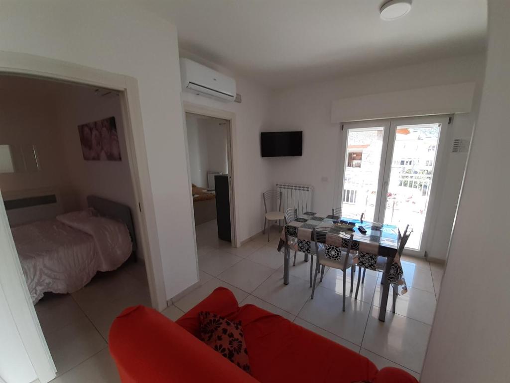 a living room with a red couch and a table at San Marco Beach App Libeccio in Agropoli