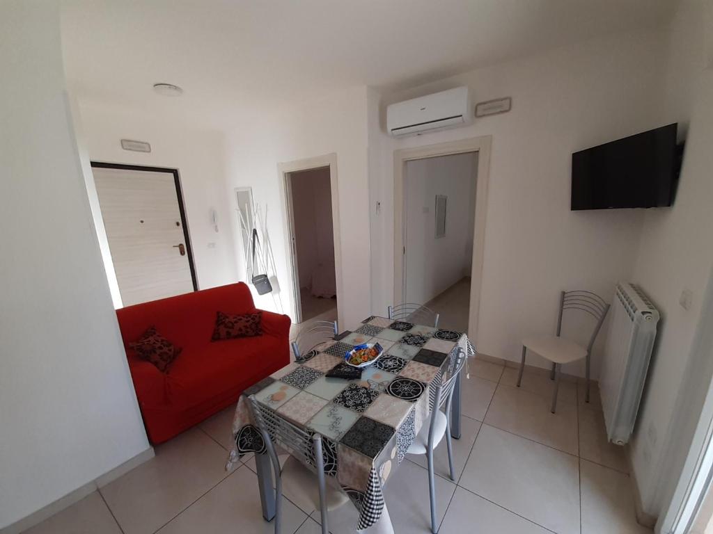 a living room with a red couch and a table at San Marco Beach App Libeccio in Agropoli