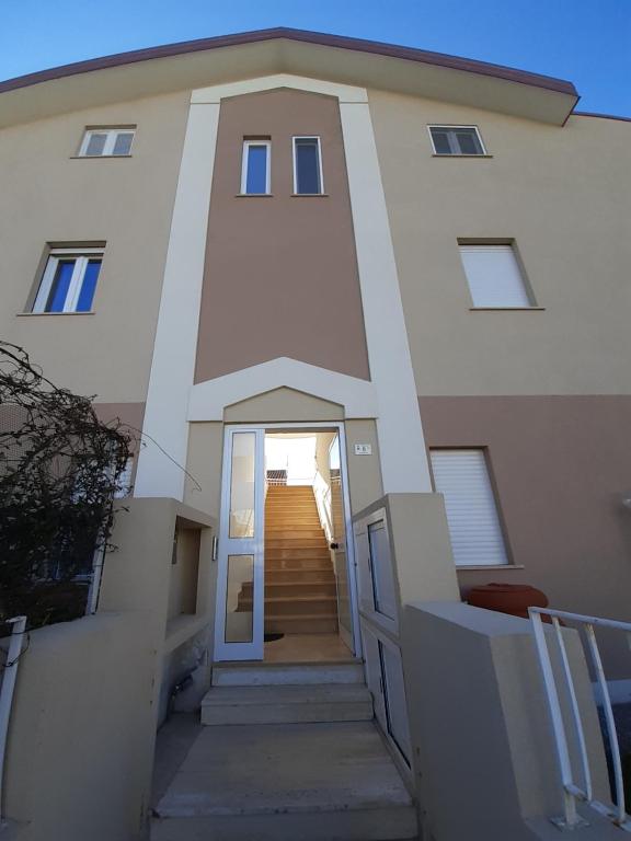 a large white building with a staircase in front of it at San Marco Beach App Libeccio in Agropoli