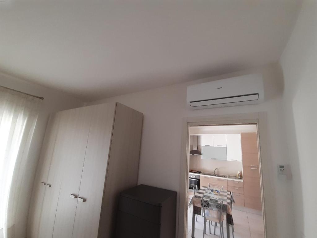 a white room with a table and a kitchen at San Marco Beach App Libeccio in Agropoli