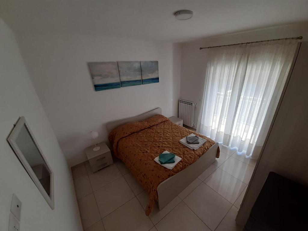 a small bedroom with a bed and a television at San Marco Beach App Libeccio in Agropoli