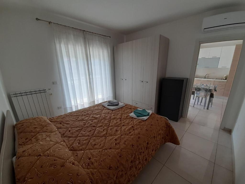 a bedroom with a bed with a brown comforter at San Marco Beach App Libeccio in Agropoli