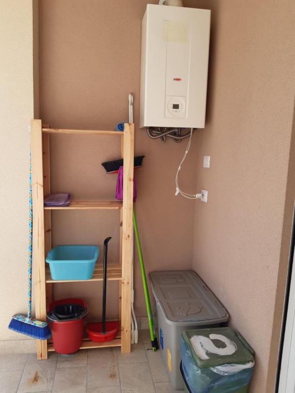 a utility room with a washing machine and a shelf at San Marco Beach App Libeccio in Agropoli