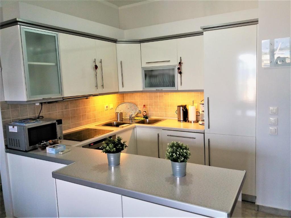a kitchen with white cabinets and a counter top at Potamos apartment with view in Potamós