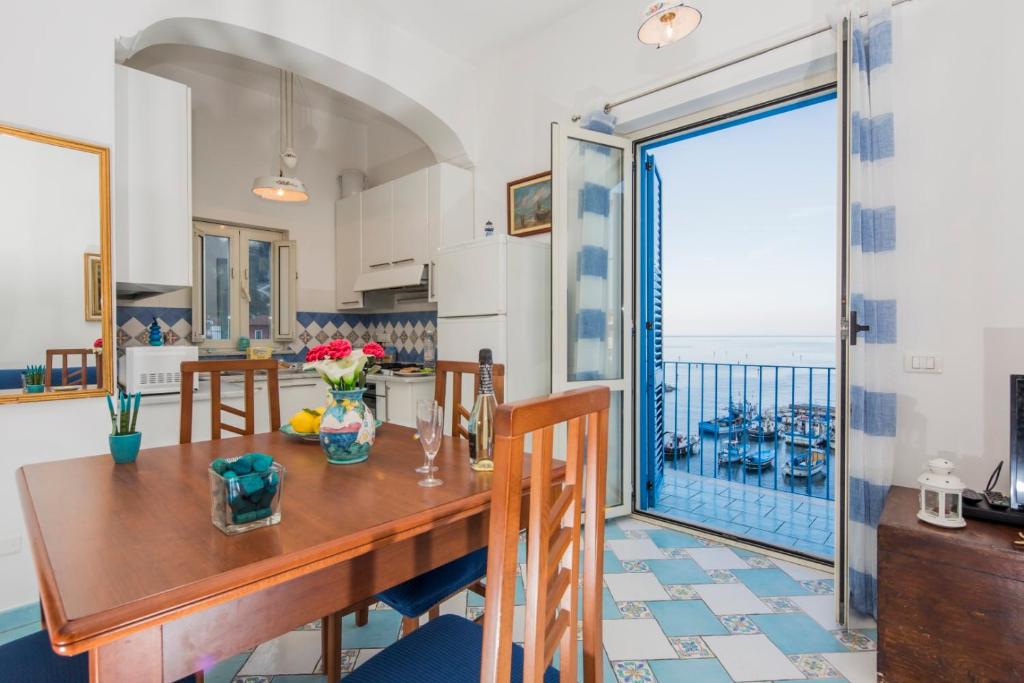 een keuken en eetkamer met een tafel en een groot raam bij Marina Grande,102 - Blue Horizon Sorrento in Sorrento