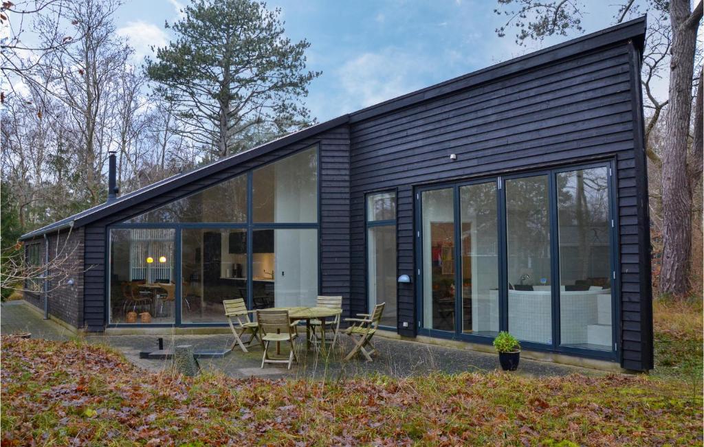 a black house with a table and chairs at Amazing Home In Græsted With Kitchen in Græsted