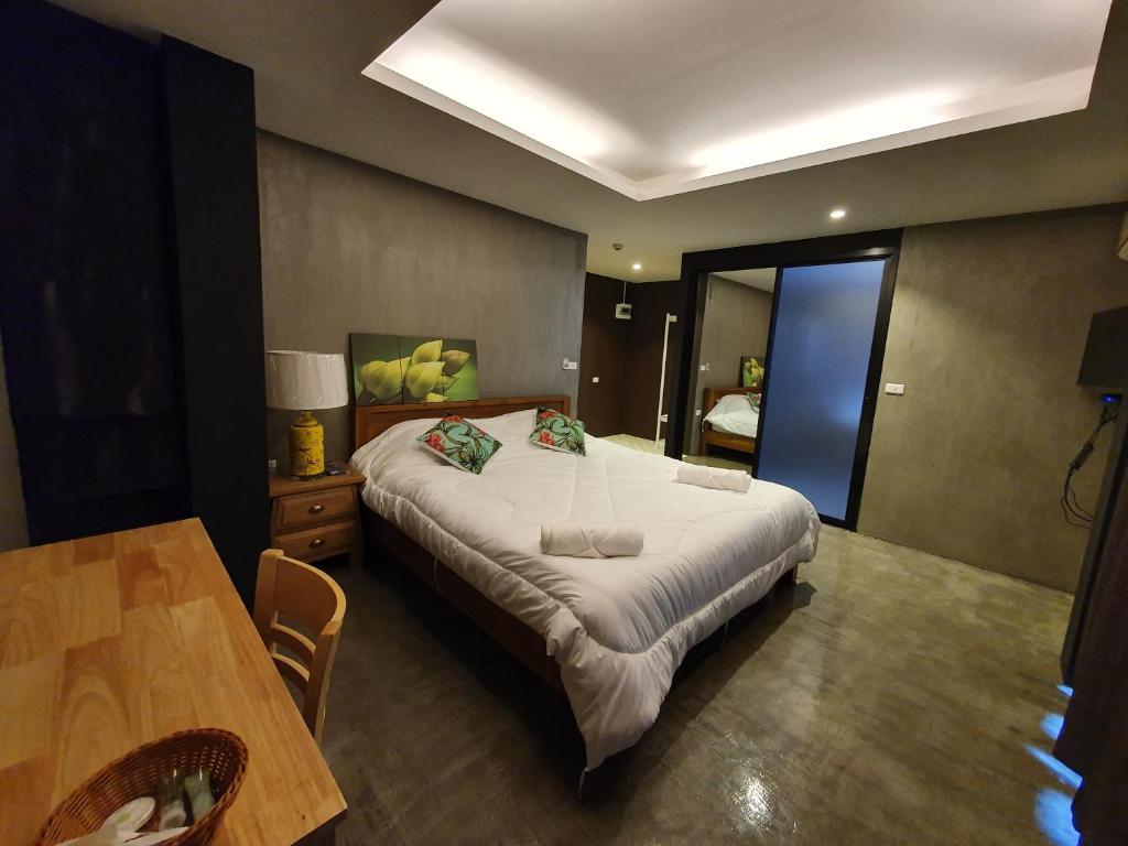 sypialnia z dużym łóżkiem i stołem w obiekcie Baan Wualamphong บ้านวัวลำพอง w mieście Bangkok