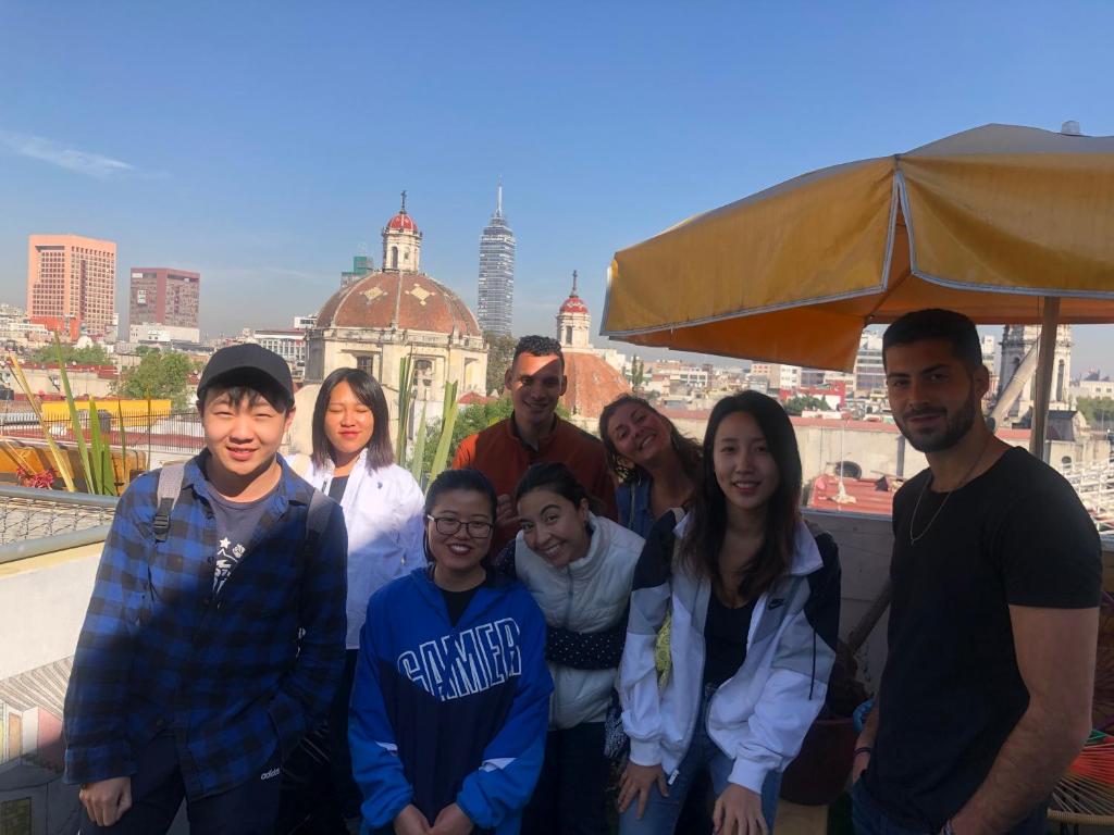 un grupo de personas posando para una foto frente a la ciudad en Casa Eufemia Hostel type en Ciudad de México