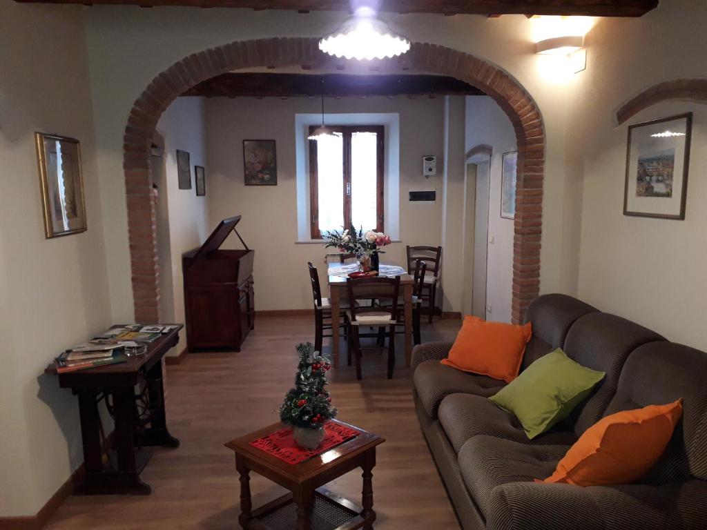 een woonkamer met een bank en een tafel bij Dinas House Tuscany Holidays in Terricciola