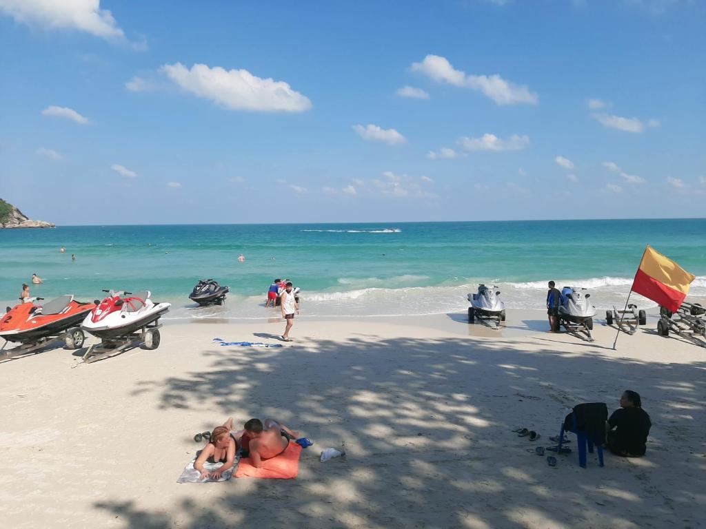 a group of people sitting on a beach at Sunrise Resort- Koh Phangan - SHA Extra Plus in Haad Rin