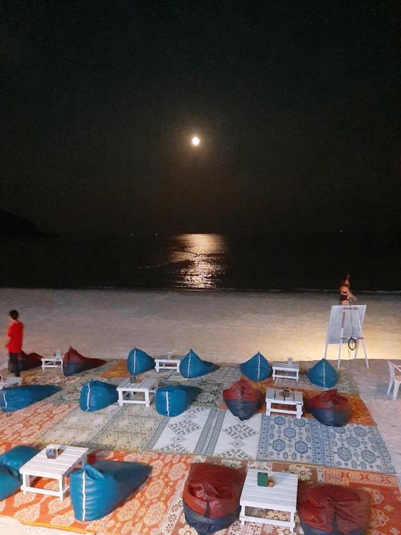a group of chairs and tables on a beach at night at Sunrise Resort- Koh Phangan - SHA Extra Plus in Haad Rin