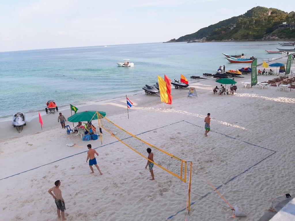 a group of people playing volley ball on a beach at Sunrise Resort- Koh Phangan - SHA Extra Plus in Haad Rin