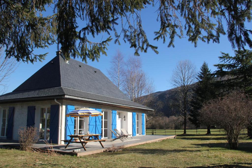 a small blue and white house with a picnic table at Gite l'Estibère en Val d'Azun in Aucun