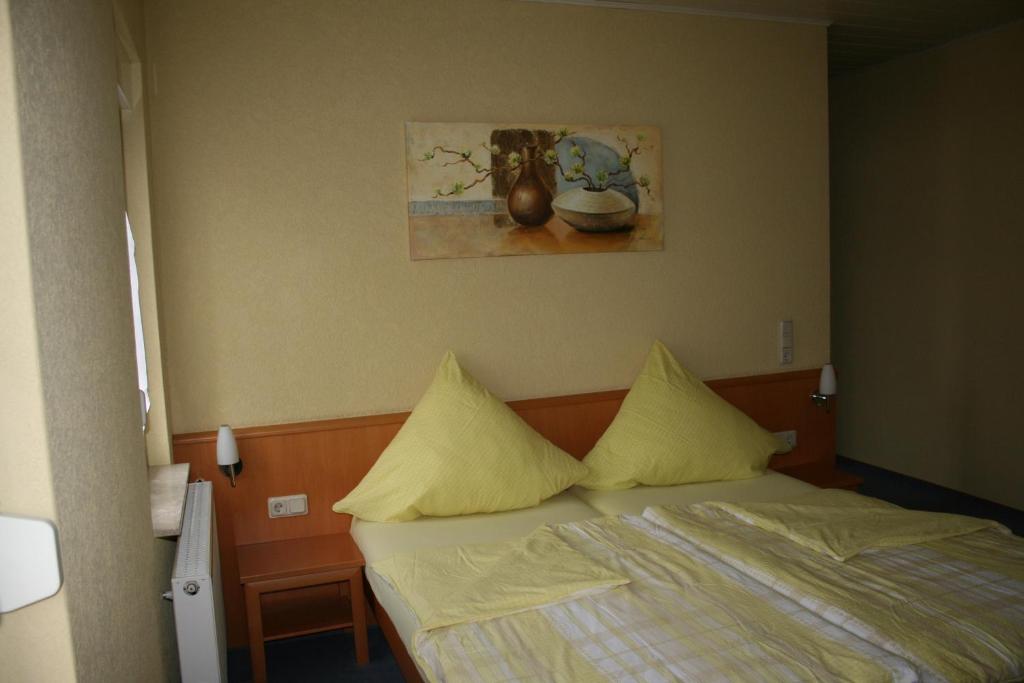 a bedroom with a bed with yellow pillows at Pension zur Krone in Eisenach