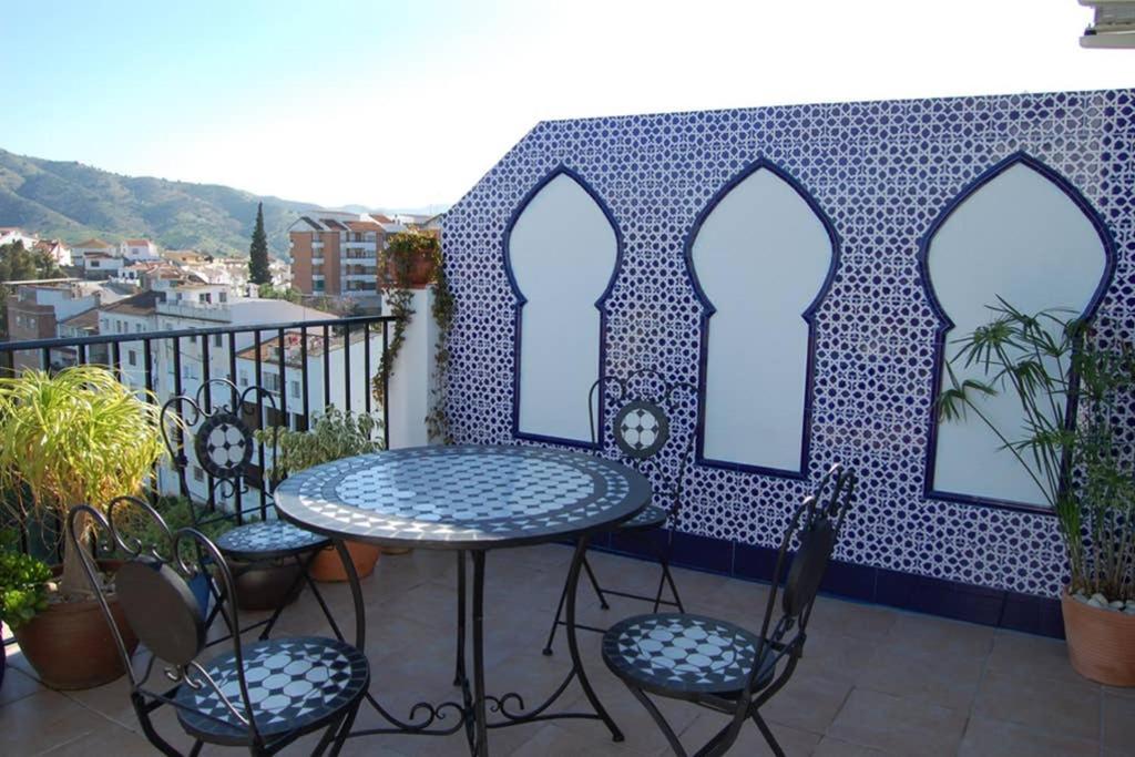 a patio with a table and chairs on a balcony at One bedroom penthouse in Alora