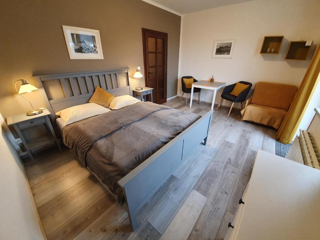a bedroom with a large bed and a living room at Pension Sport in Špindlerův Mlýn