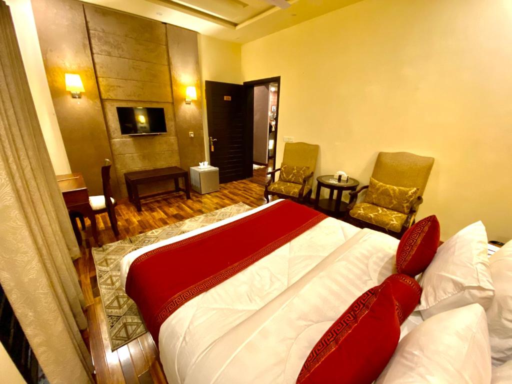 ラホールにあるShelton’s Rezidor Lahoreのベッドルーム1室(ベッド1台、椅子2脚、テーブル付)
