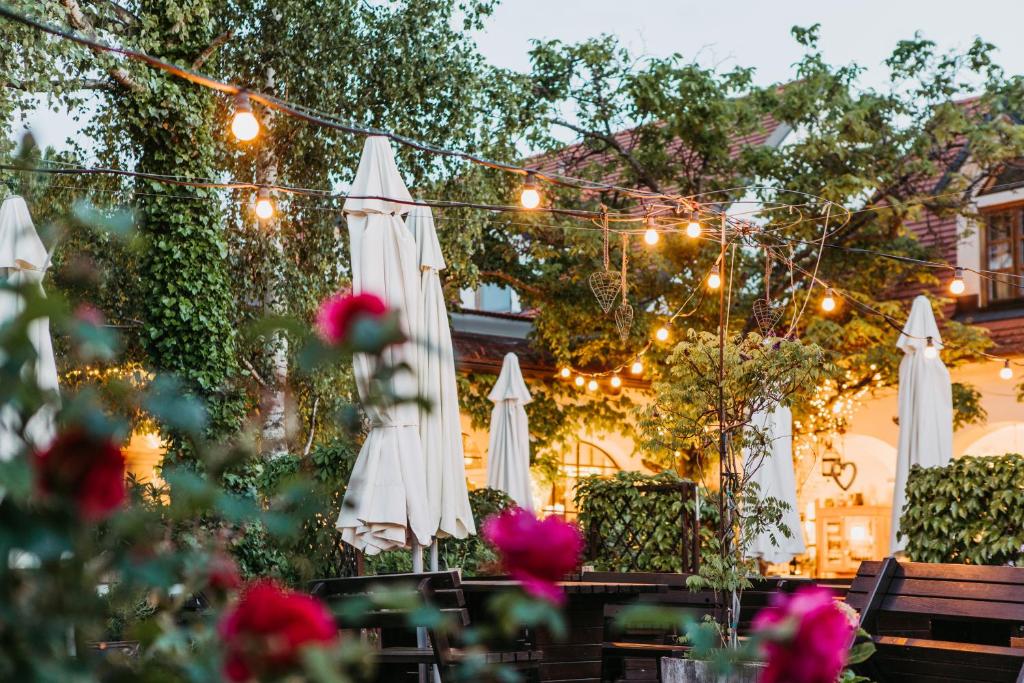 an outdoor patio with white umbrellas and lights at Oleander Romantik Zimmer in Trausdorf