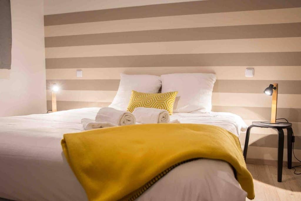 une chambre avec un lit avec une couverture jaune dessus dans l'établissement La cour du faubourg 3, à Strasbourg