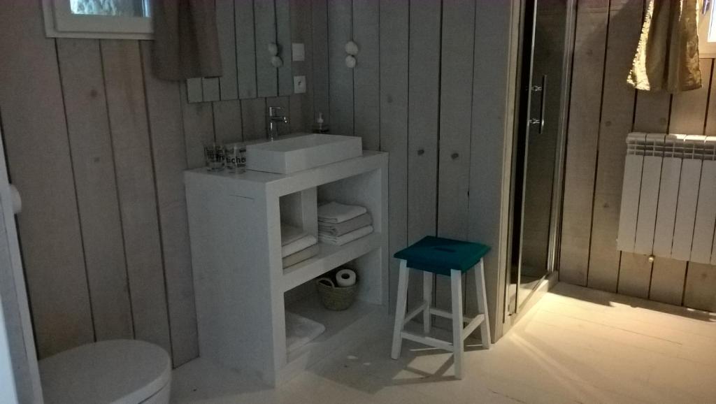 a bathroom with a white sink and a stool at Mas des 4 Vents in Fitou