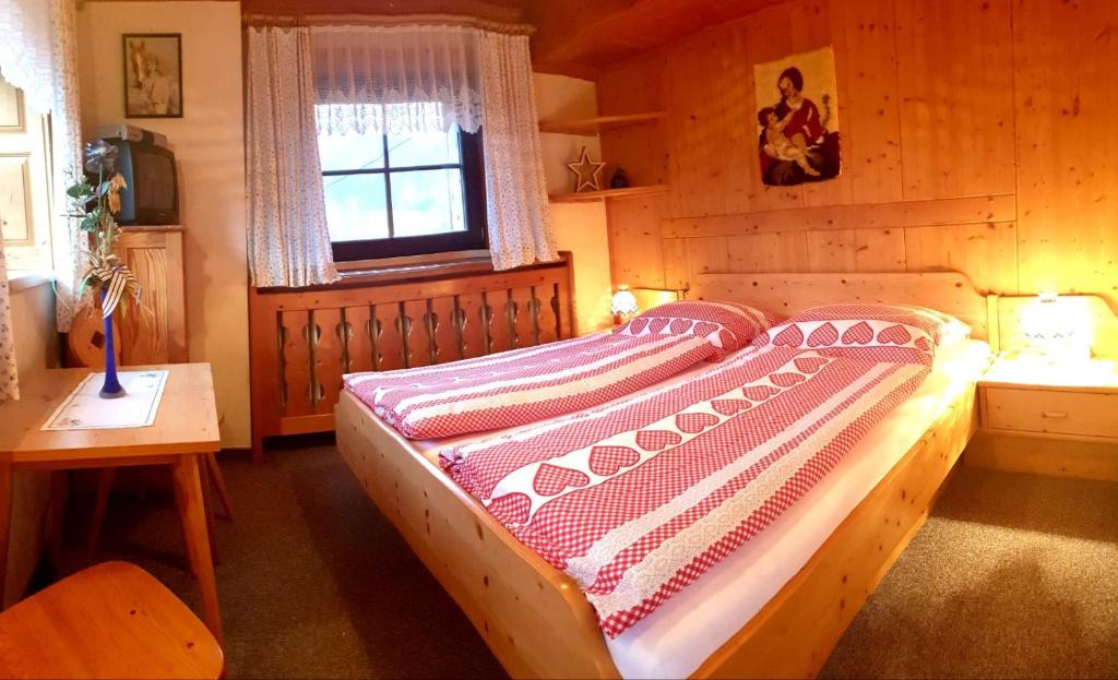 ein Schlafzimmer mit einem Bett in einem Holzzimmer in der Unterkunft Mühlnerhof Familie Gruber in Aich