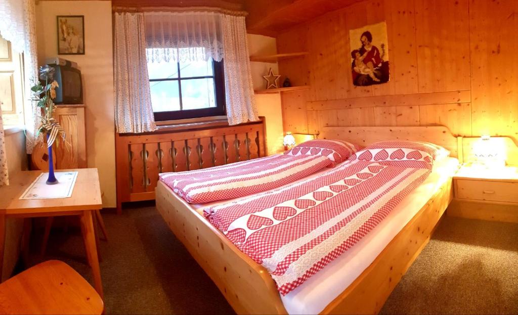 a bedroom with a bed in a wooden room at Mühlnerhof Familie Gruber in Aich