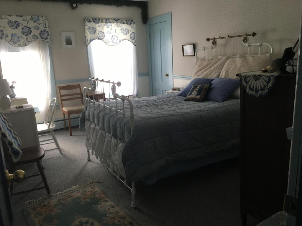 a bedroom with a bed and two windows at Timber Post Bed & Breakfast in Nashua