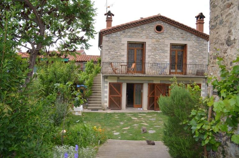 Casa de piedra grande con balcón en la parte superior. en Gîte 3 étoiles chez Nath et Tony, en Taurinya