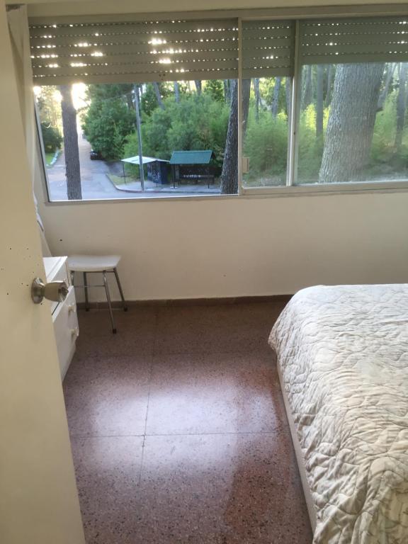 1 dormitorio con 1 cama y ventana con mesa en hermoso apto en complejo agreste con piscina en punta del este!!, en Punta del Este