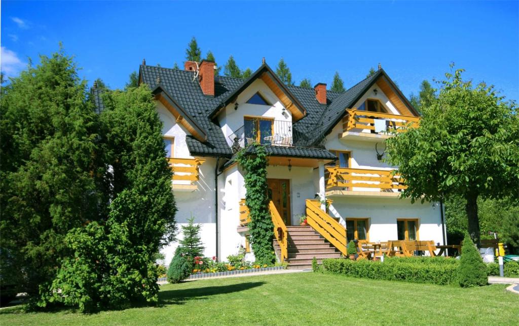 a large white house with a roof at Willa Modrysówka in Zawoja