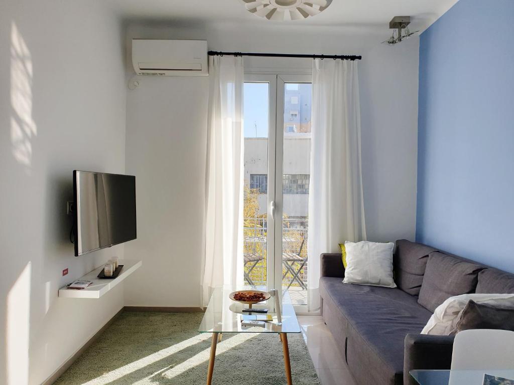 uma sala de estar com um sofá e uma televisão em KYMA Apartments - Athens Acropolis 7 em Atenas