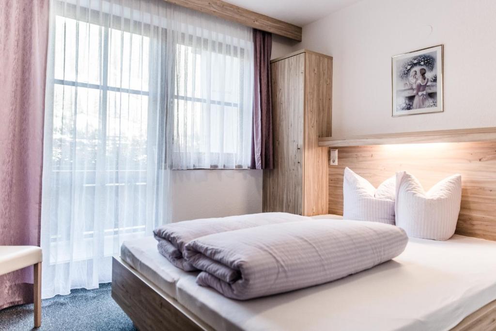 1 dormitorio con 1 cama y ventana grande en Appartement Grüner Fidelis, en Sölden