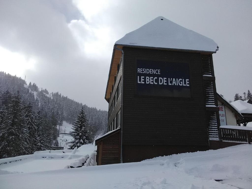 Un bâtiment avec un panneau dans la neige dans l'établissement Le Lioran Studio les Myrtilles à 200m des pistes, à Le Lioran