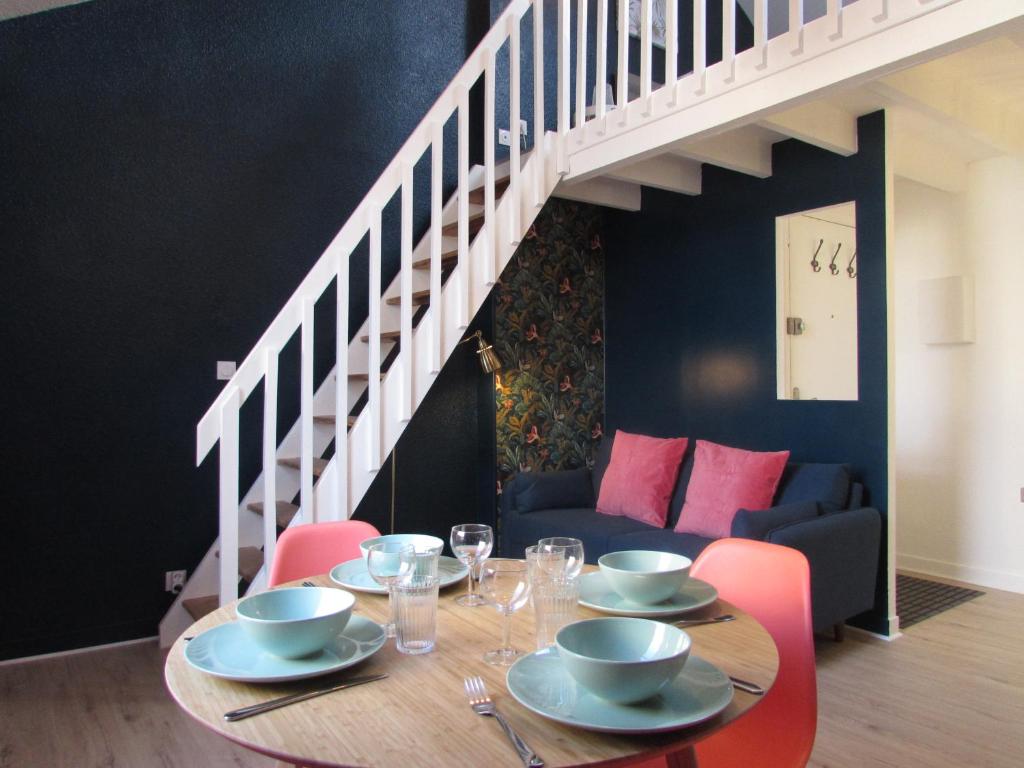 a dining room with a table with chairs and a staircase at Appartement LE SACRE CŒUR - 2 chambres in Rennes