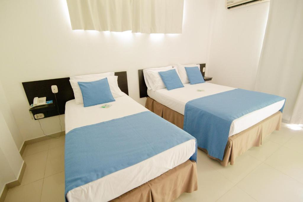 Postel nebo postele na pokoji v ubytování Hotel Maranata Valledupar
