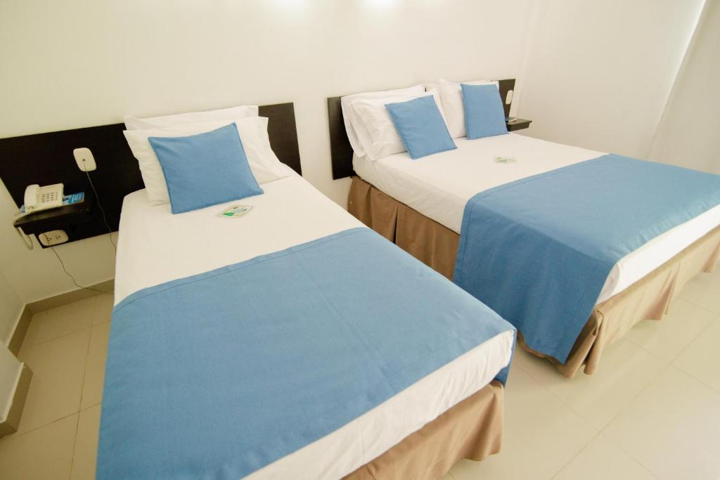 Postel nebo postele na pokoji v ubytování Hotel Maranata Valledupar