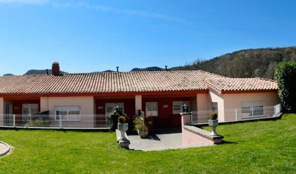 a house with two cats sitting outside of it at Apartaments Can Xel in Santa Pau