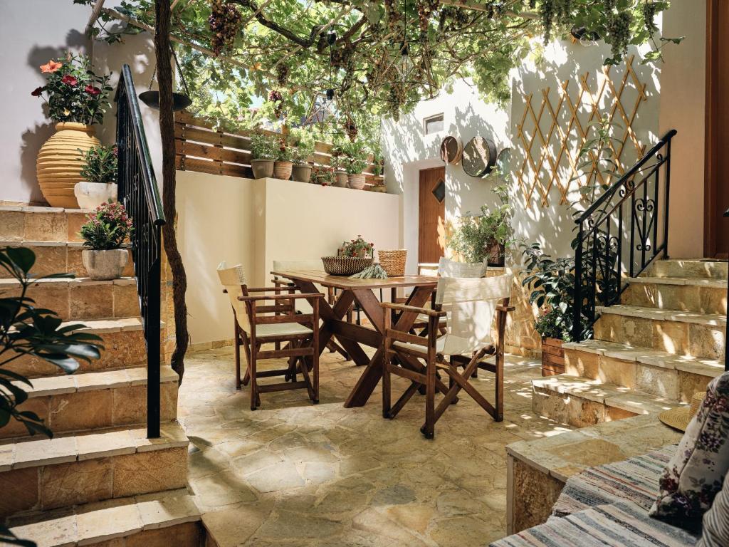comedor con mesa, sillas y plantas en Joya Village House, en Agios Leon