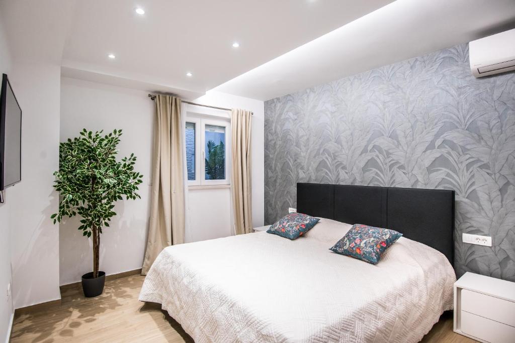 - une chambre avec un lit et une plante en pot dans l'établissement Dubrovnik Spectrum Rooms, à Dubrovnik