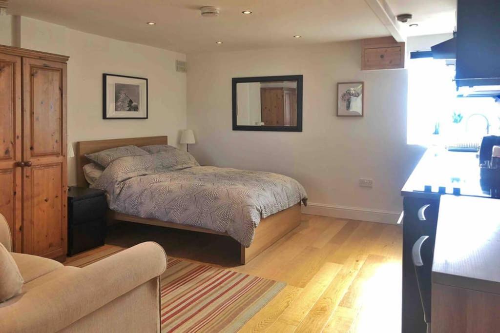 a bedroom with a bed and a couch at Modern Studio Apartment Near Town Centre in Poole