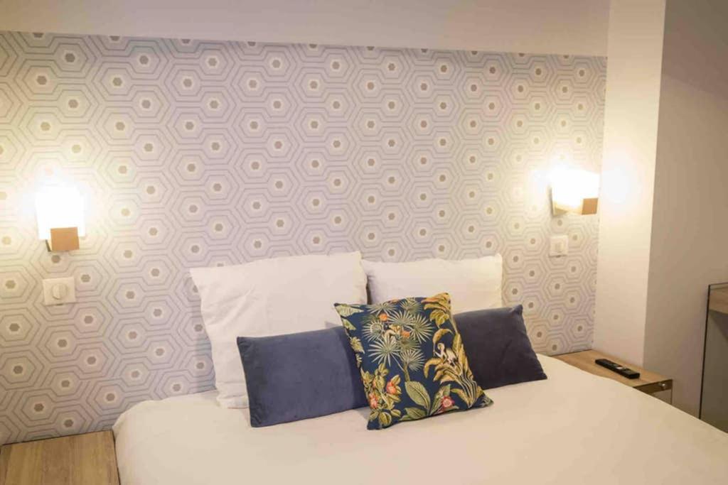 une chambre avec un lit blanc avec deux oreillers dans l'établissement La Cour du Faubourg 1 (LCDF1), à Strasbourg