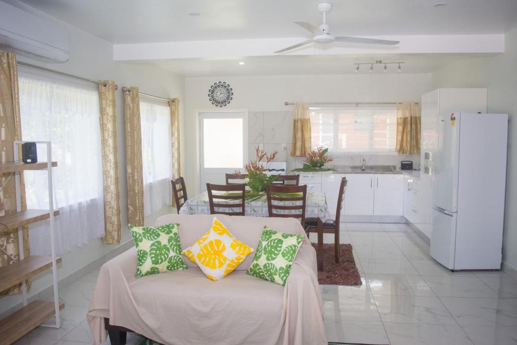 a living room with a couch and a kitchen at MOEROA VILLAS in Avatiu