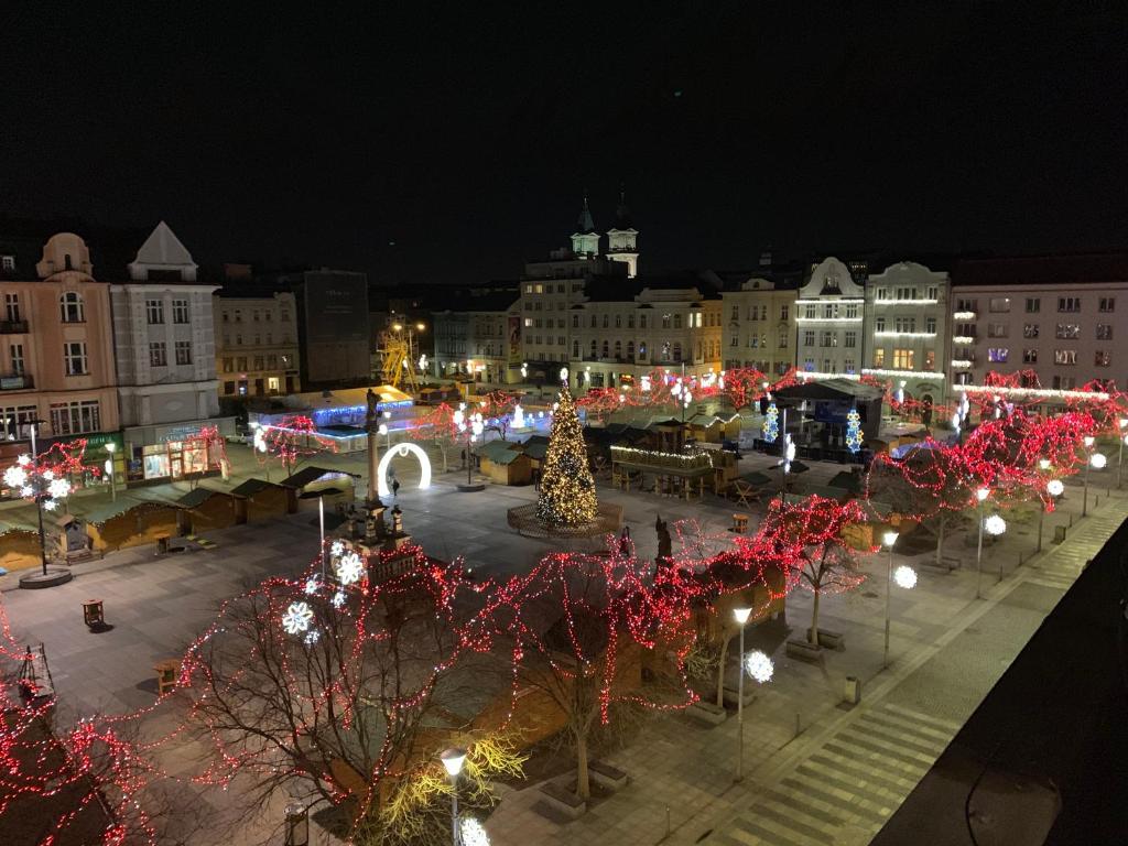 Studio Ostrava - Masarykovo náměstí في أوسترافا: سوق عيد الميلاد في مدينة في الليل