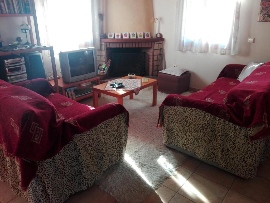 uma sala de estar com dois sofás e uma televisão em Cosy house in Galaxidi em Galaxidi