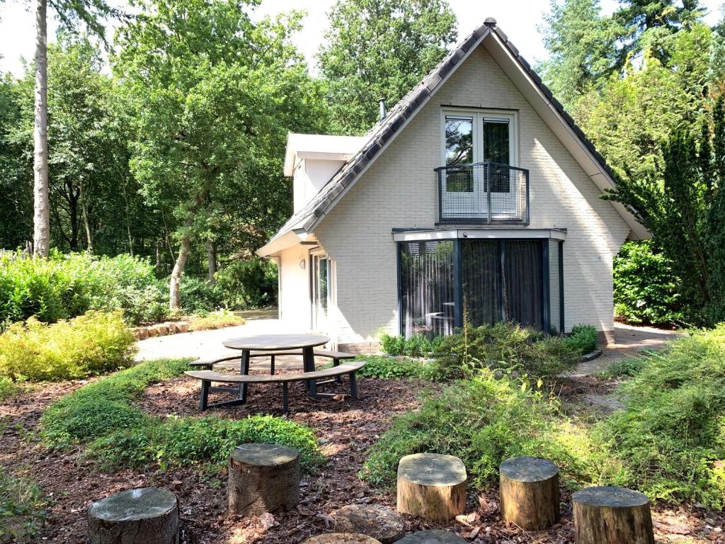 a picnic table in front of a house at Vakantiehuis Bos en Hei Veluwe in Epe