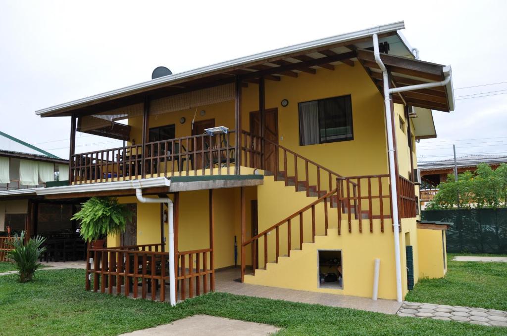 a yellow house with a staircase on it at Marfi Inn in Cahuita